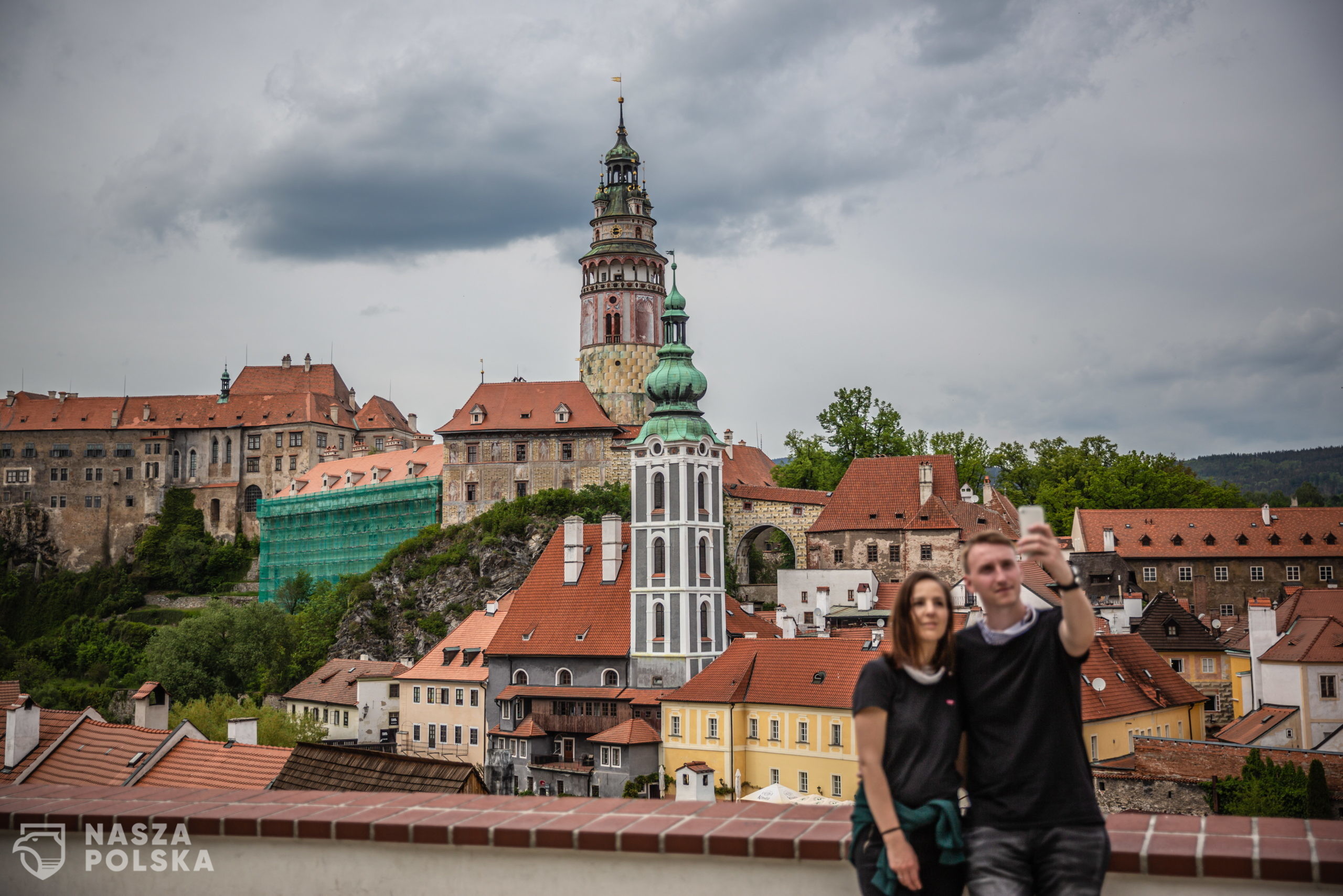 epa08438217 A couple takes selfie at almost empty vantage point above the old town of Cesky Krumlov, UNESCO World Culture Heritage site, Czech Republic, 22 May 2020. According to local media, more than 15.000 tourists from Asia arrived in the South Bohemian region, where is located the popular tourist destination Cesky Krumlov, on January 2020. Due to the pandemic COVID-19 disease caused by the SARS-CoV-2 coronavirus, which closed borders and restricted travel, the number of accommodated tourists in southern Bohemia fell by 30 percent in the first quarter. The region is the most affected in the country.  EPA/MARTIN DIVISEK 
Dostawca: PAP/EPA.