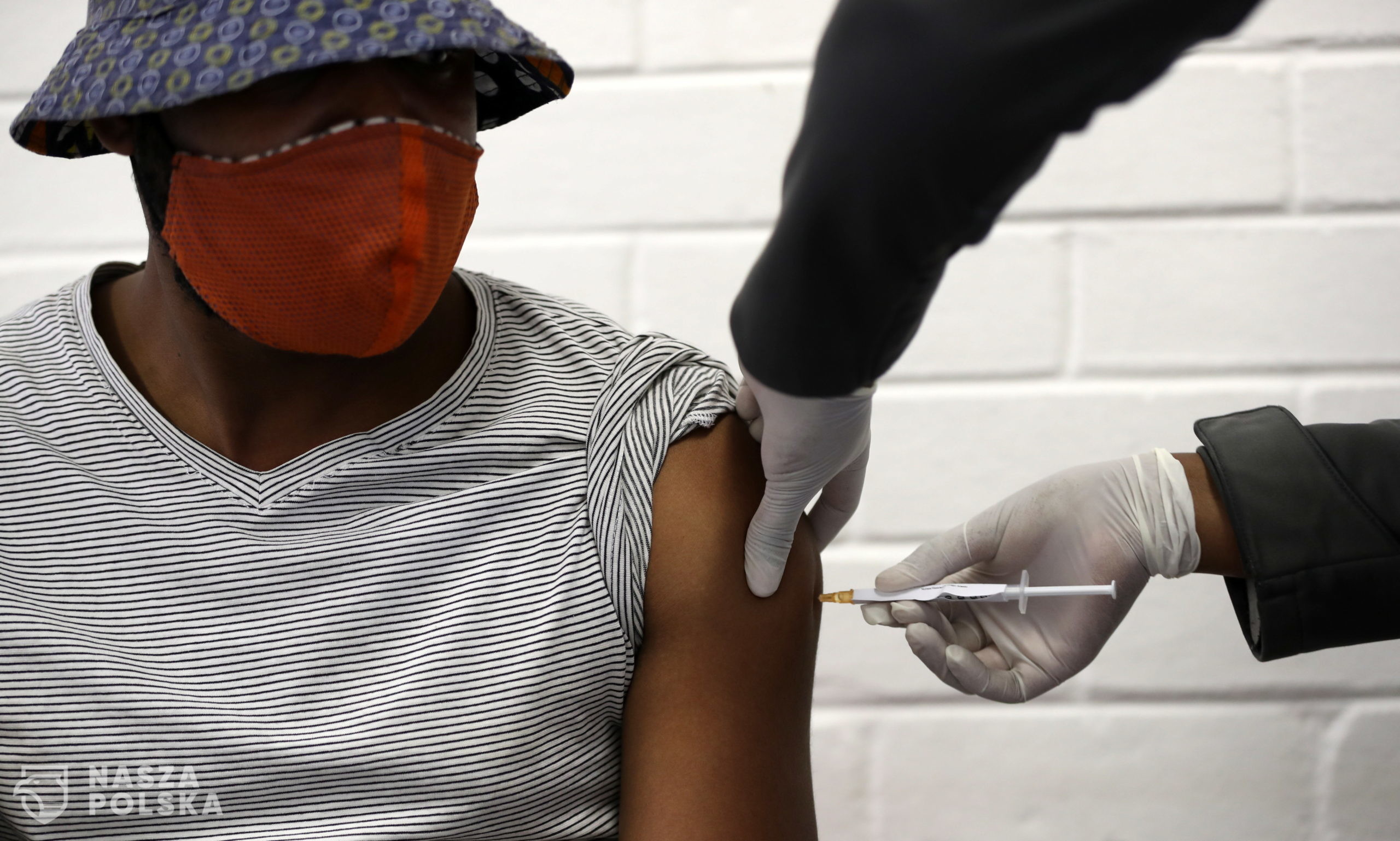 epa08505895 One of the first South African vaccine trialists gets injected during the clinical trial for a potential vaccine against the Covid-19 Corona virus at the Baragwanath hospital in Soweto, South Africa, 24 June 2020. 2000 South African volunteers are set to be given the Wits and Oxford Universities vaccine for COVID-19 over the next two months. 7,000 more people in the UK and 10,000 in the US would also take part in the trial.  EPA/SIPHIWE SIBEKO / POOL 
Dostawca: PAP/EPA.