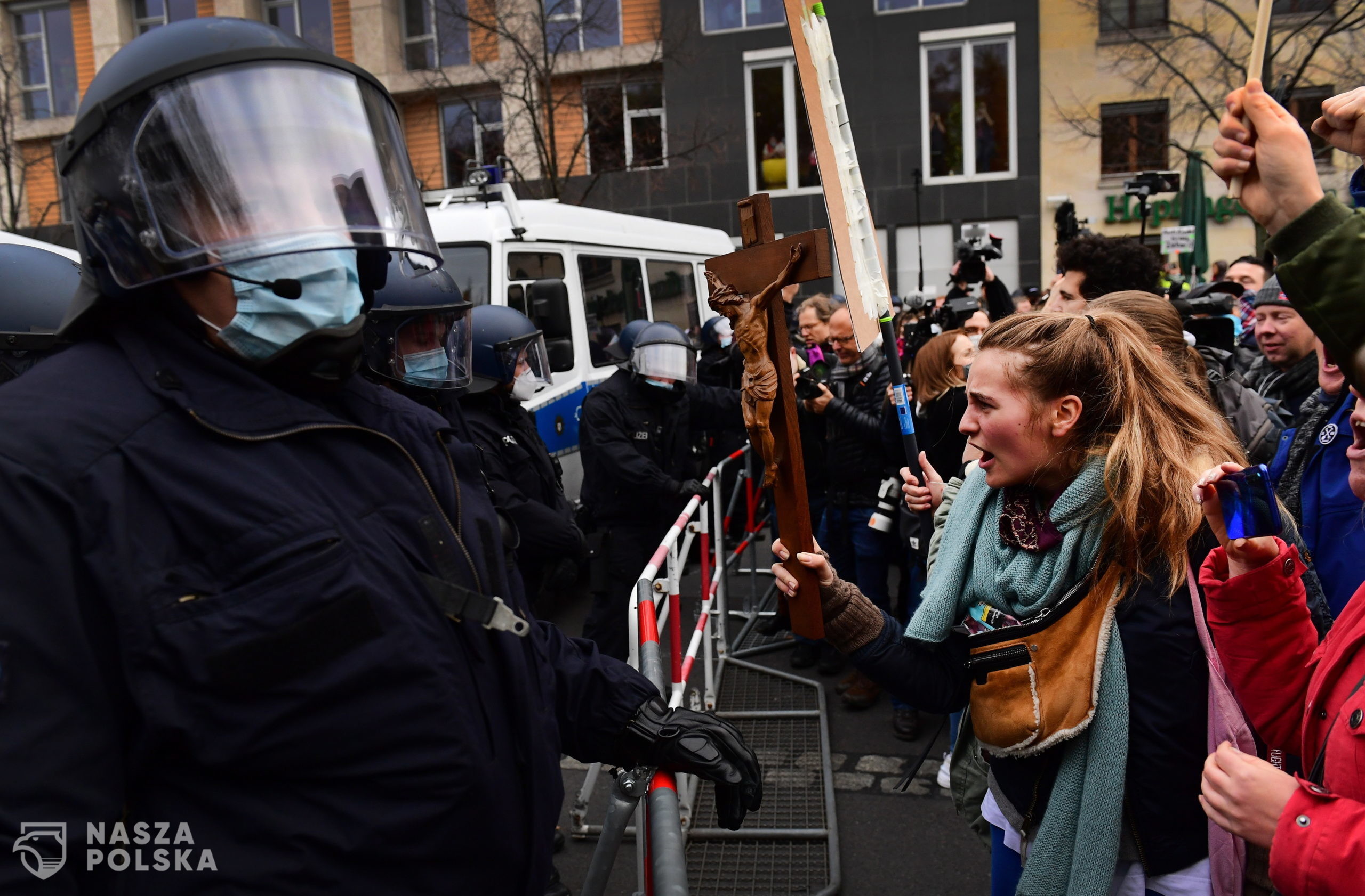 epa08826672 A protester holds out a crucifix towards police officers during a demonstration against German coronavirus restrictions, in Berlin, Germany, 18 November 2020. While German interior minister prohibited demonstrations around the Reichstag building during the parliamentary Bundestag session people gathered to protest against government-imposed semi-lockdown measures aimed at curbing the spread of the coronavirus pandemic. Since 02 November, all restaurants, bars, cultural venues, fitness studious, cinemas and sports halls are forced to close for four weeks as a lockdown measure to rein in skyrocketing coronavirus infection rates.  EPA/FILIP SINGER 
Dostawca: PAP/EPA.