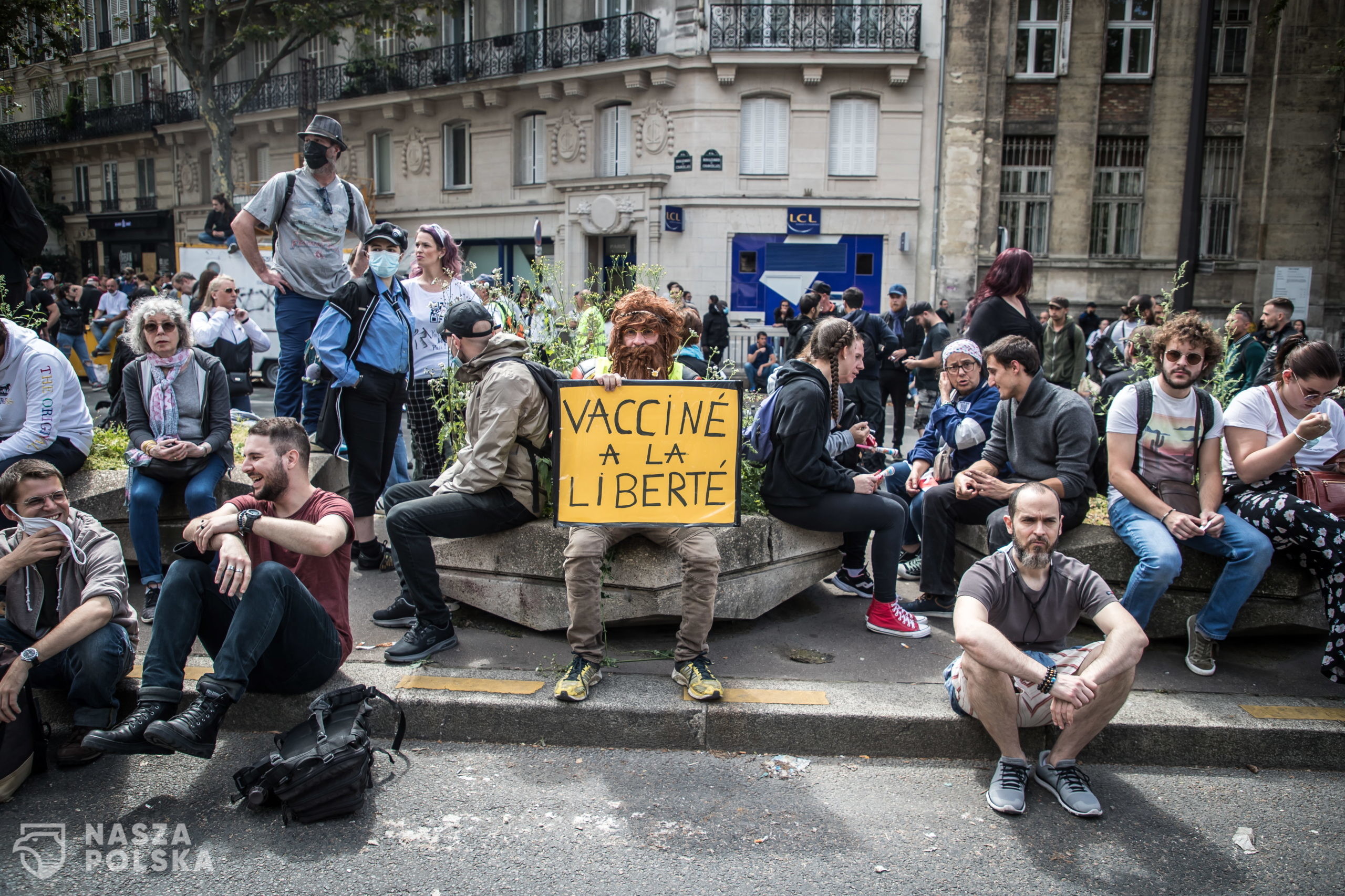 epa09382553 A protester holds a poster reading 'Vaccinated with freedom' during a demonstration against the COVID-19 health pass which grants vaccinated individuals greater ease of access to venues in France, in Paris, France, 31 July 2021. Anti-vaxxers, joined by the anti-government 'yellow vest' movement, are demonstrating across France for the third consecutive week in objection to the health pass, which is now mandatory for people to  visit leisure and cultural venues.  EPA/CHRISTOPHE PETIT TESSON 
Dostawca: PAP/EPA.