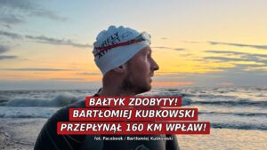 Bartłomiej Kubkowski w piance na brzegu Bałtyku o zachodzie słońca, w czepku pływackim i z latarką czołową