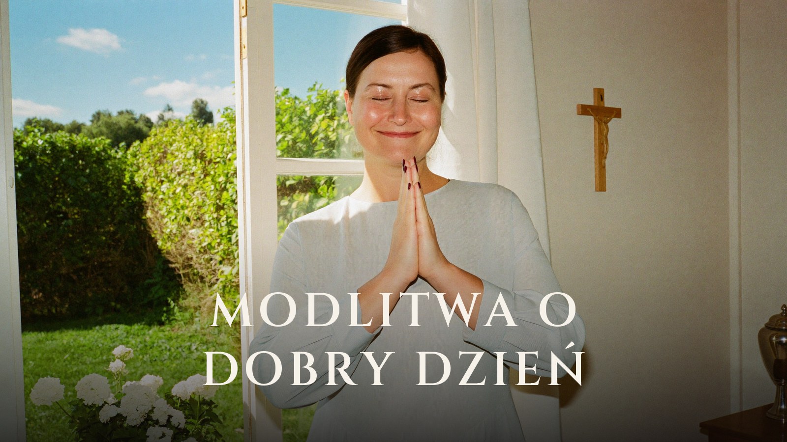 Kobieta ze złożonymi dłońmi modli się przy otwartym oknie w słoneczny poranek