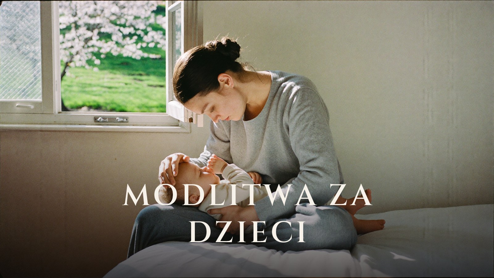 Matka trzyma niemowlę na kolanach i modli się przy otwartym oknie