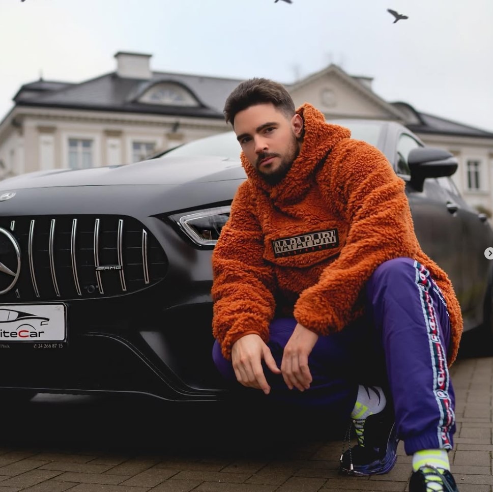 Stuart Alexander Kluz-Burton, youtuber Stuu z afery Pandora Gate, kuca przy czarnym mercedesie