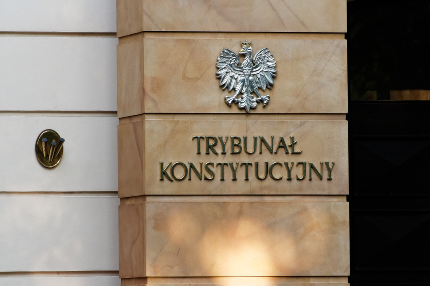 Tablica z godłem państwowym i napisem Trybunał Konstytucyjny na kamiennej elewacji siedziby sądu konstytucyjnego w Warszawie