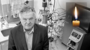 Profesor Andrzej Mackiewicz w laboratorium biotechnologicznym, po prawej stronie pali się świeca, kadr czarno-biały