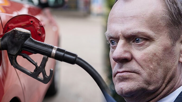 Pistolet dystrybutora we wlewie czerwonego auta, po prawej stronie kadru premier Donald Tusk