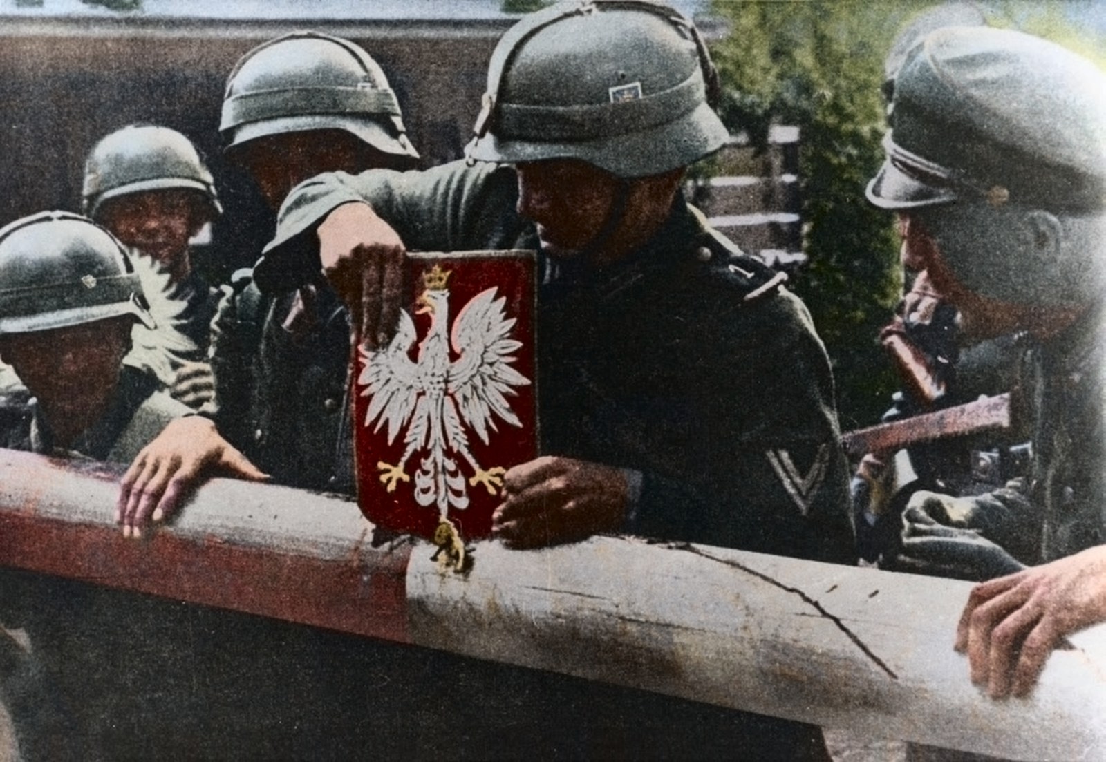 Niemieccy żołnierze zrywają godło z orłem z polskiego szlabanu granicznego 1 września 1939 roku
