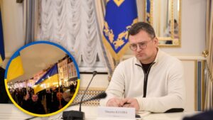 Dmytro Kuleba podczas wystapienia, w tle flagi