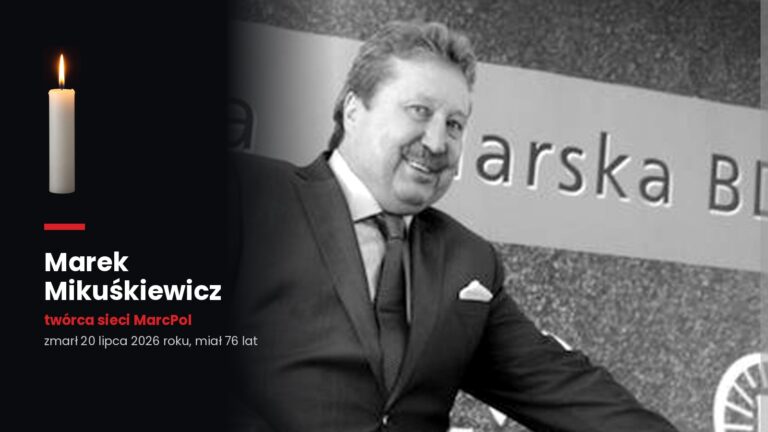 Marek Mikuśkiewicz w garniturze przy rowerze szosowym podczas prezentacji drużyny kolarskiej, obok zapalona świeca