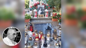 Znicze, kwiaty i fotografia ks. Stanisława Zbojnowicza przy pomniku ks. Jerzego Popiełuszki, w rogu portret kapłana