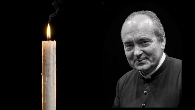 Czarno-biały portret ks. Stanisława Małkowskiego w koloratce, obok zapalona świeca na czarnym tle