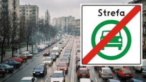 Samochody stoją w korku na wielopasmowej ulicy w mieście, obok duży znak końca strefy czystego transportu