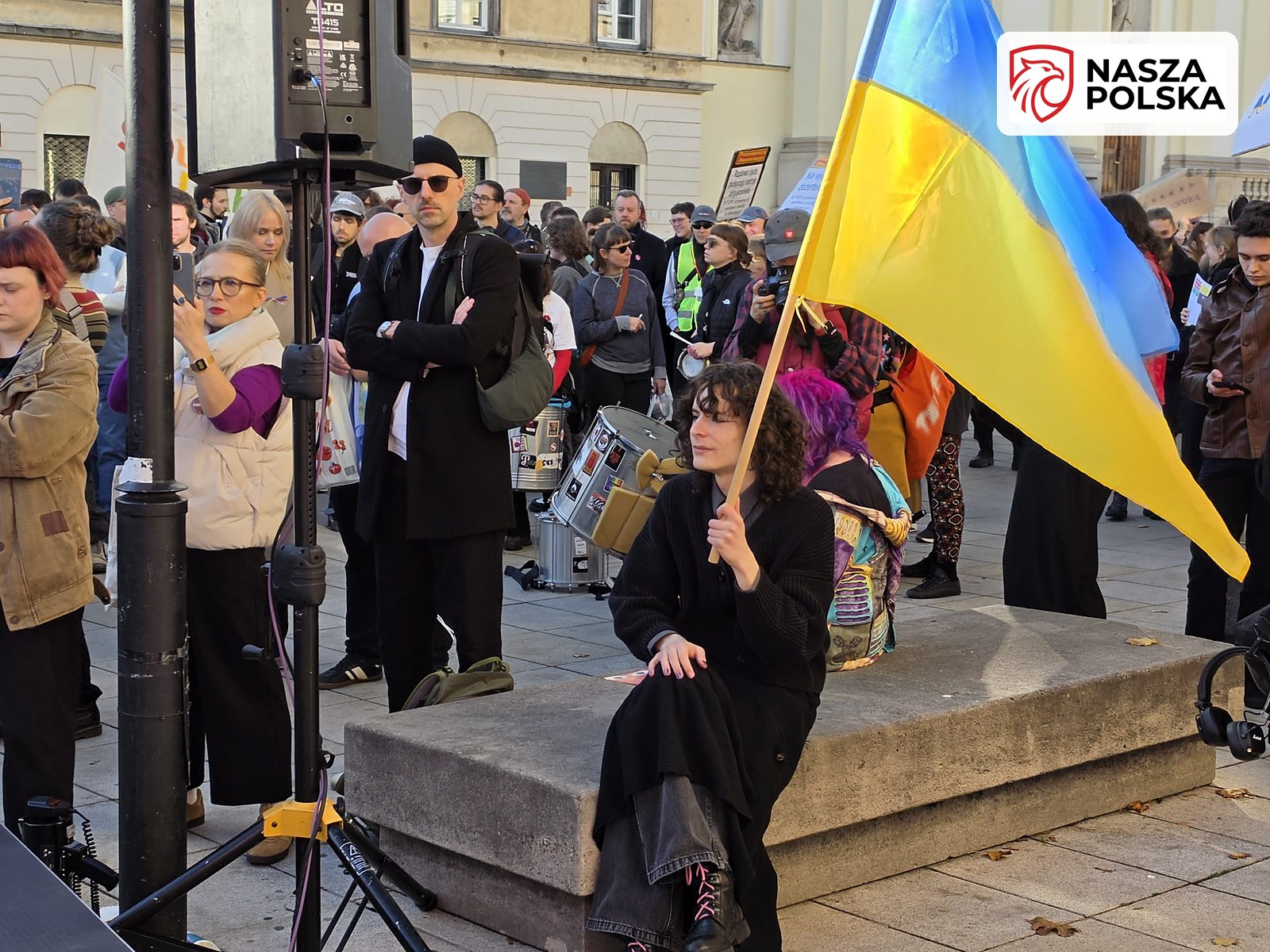 Uczestniczka manifestacji z flagą Ukrainy przy pomniku Kopernika na Krakowskim Przedmieściu