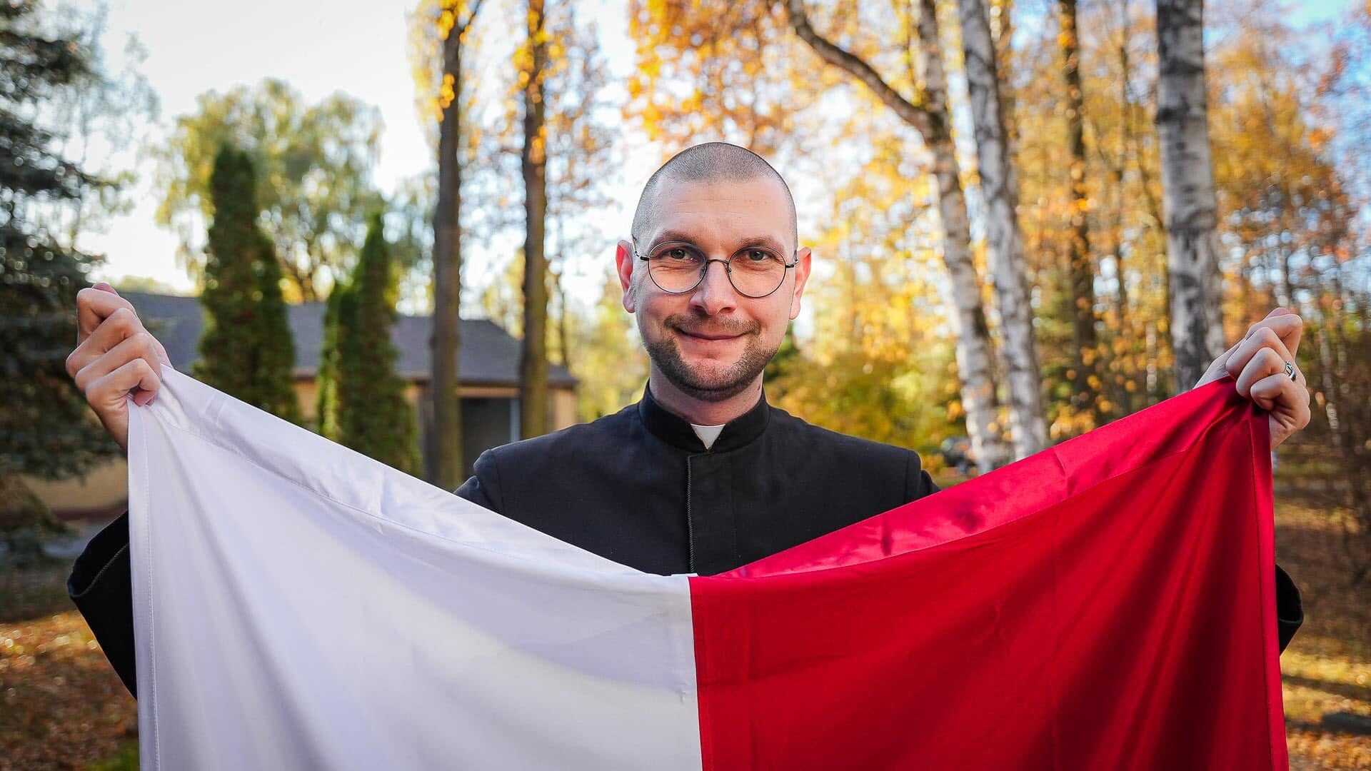 Ks. Mateusz Szerszeń CSMA, redaktor naczelny dwumiesięcznika „Któż jak Bóg”, z biało-czerwoną flagą