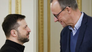 Kanclerz Niemiec Friedrich Merz uśmiecha się do prezydenta Ukrainy Wołodymyra Zełenskiego podczas powitania w pałacowej sali