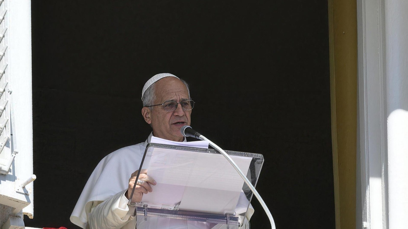Papież Leon XIV czyta rozważanie przy pulpicie w oknie Pałacu Apostolskiego w Watykanie
