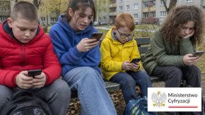 Czworo dzieci na ławce patrzy w telefony, obok logo Ministerstwa Cyfryzacji, temat zakazu mediów społecznościowych do 15 lat